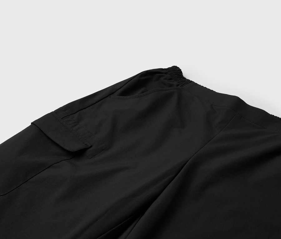 Szczegół czarnych spodni z kieszenią i elastycznym pasem.