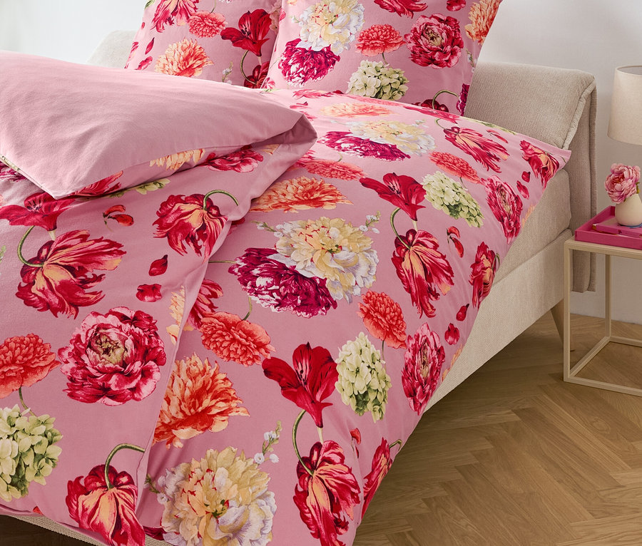 Różowa pościel w kwiaty na łóżku.