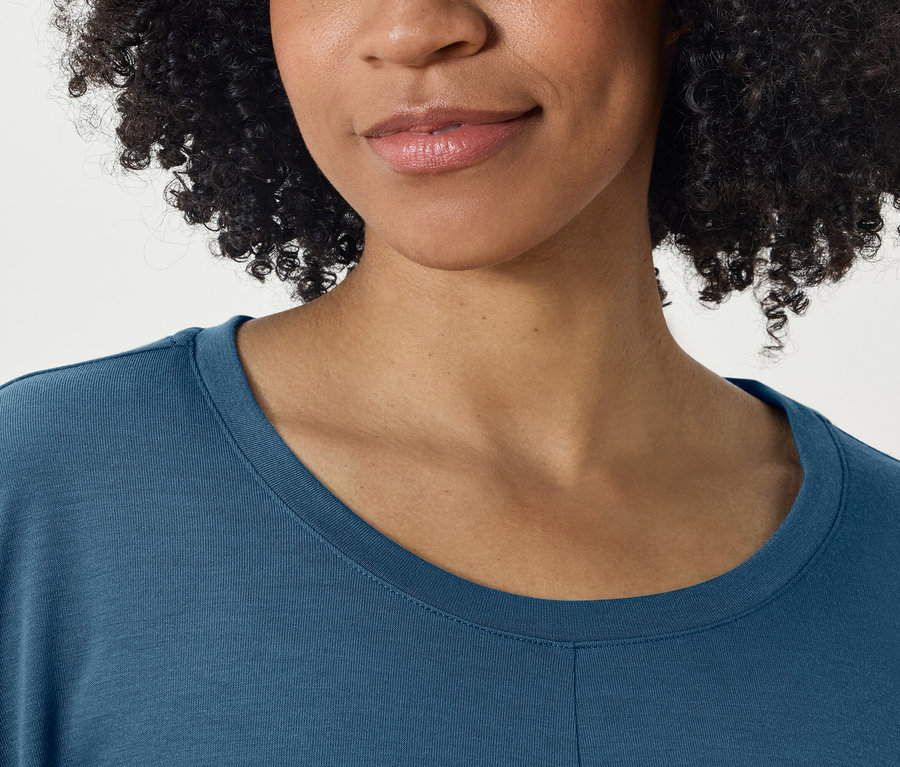 Szczegół twarzy i niebieskiej koszulki kobiety.