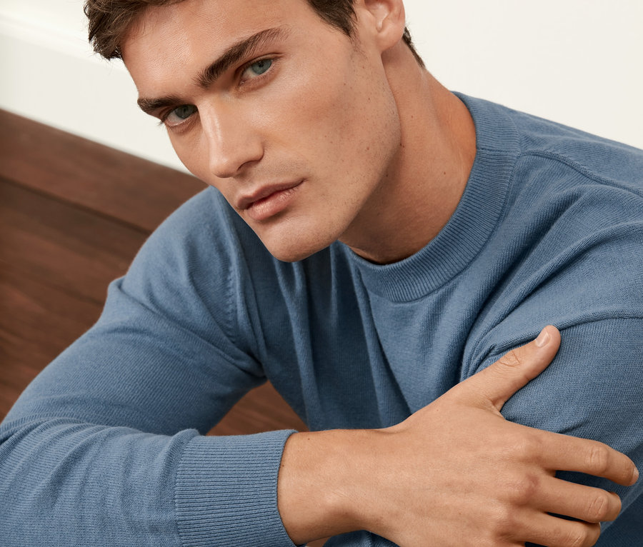 Mężczyzna ma na sobie niebieski sweter.