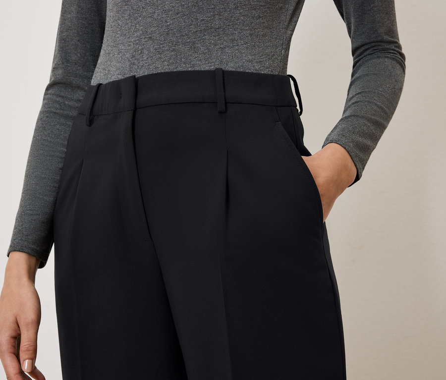 Kobieta ma rękę w kieszeni czarnych spodni.