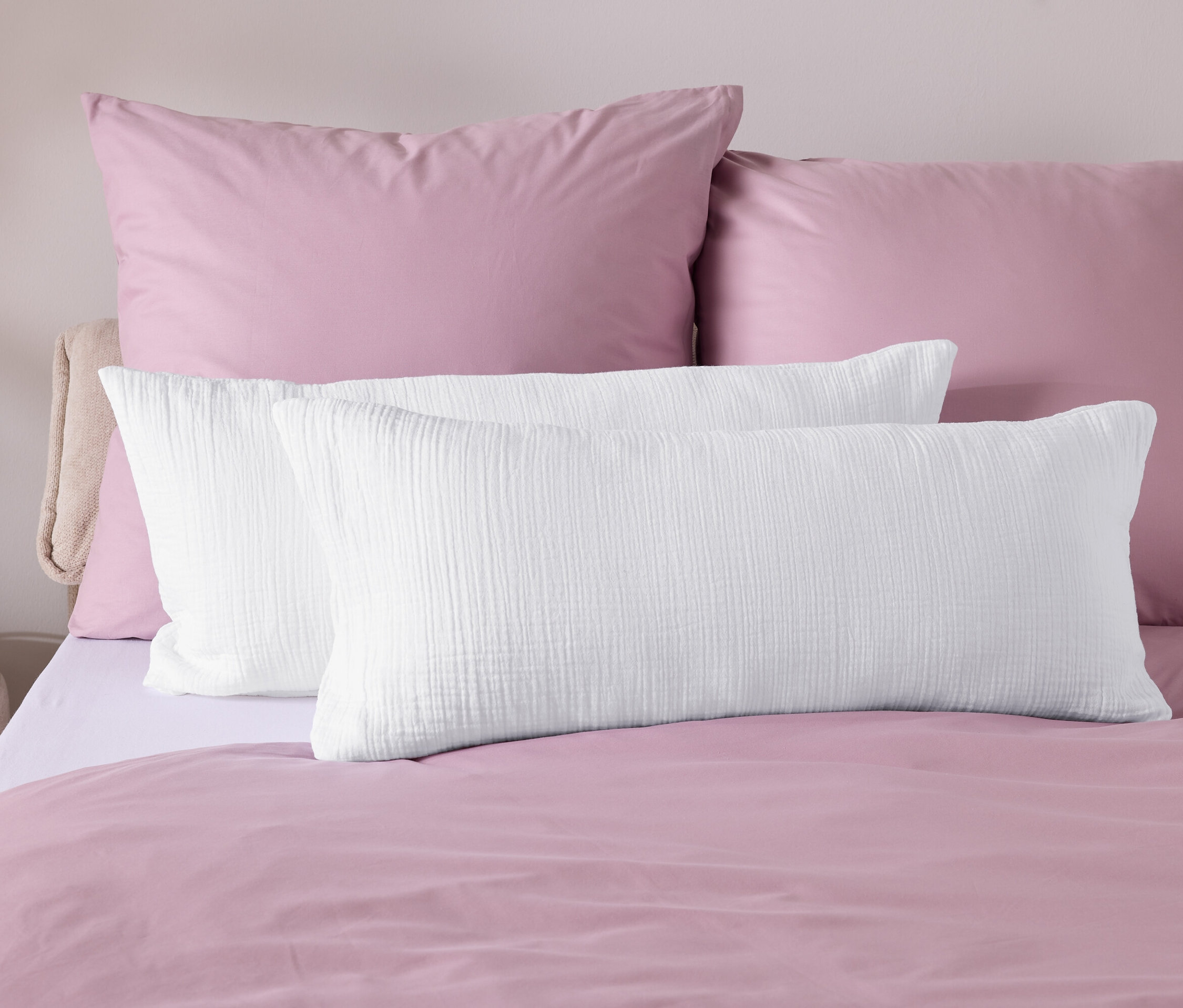 Zbliżenie pościeli z różową kołdrą i białymi poduszkami.