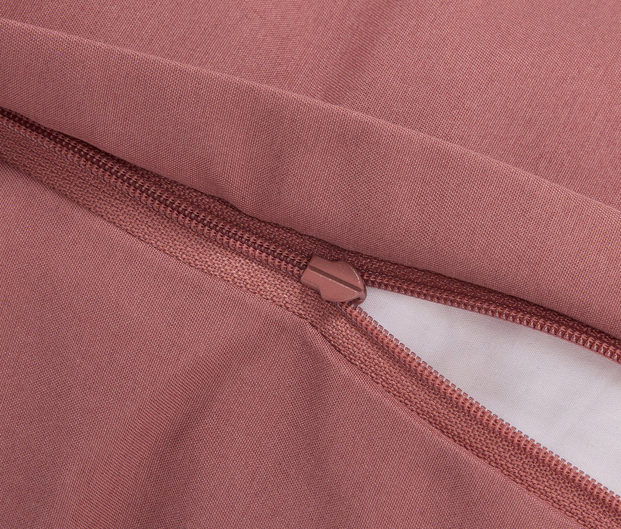 Zbliżenie różowej poszewki na kołdrę z zamkiem błyskawicznym.
