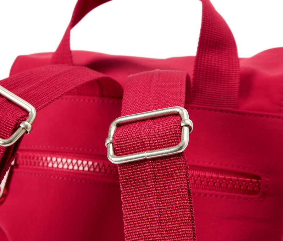 Zbliżenie czerwonego plecaka ze srebrnymi klamrami na paskach.