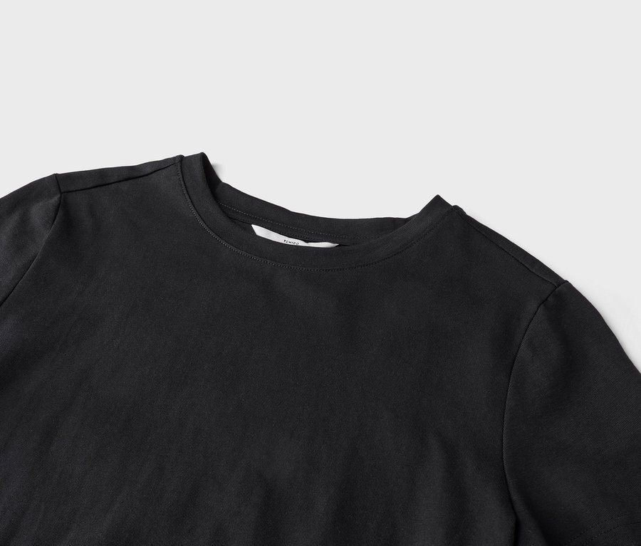 Szczegółowe ujęcie czarnego T-shirtu z okrągłym dekoltem na jasnoszarym tle.