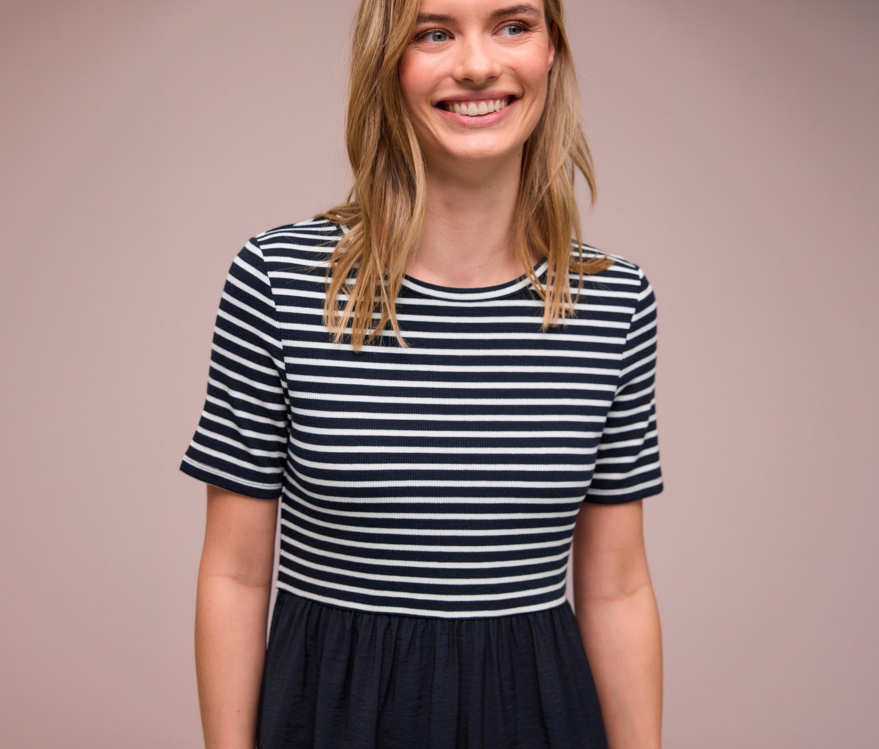 Uśmiechnięta kobieta ma na sobie sukienkę Street One w biało-niebieskie paski.