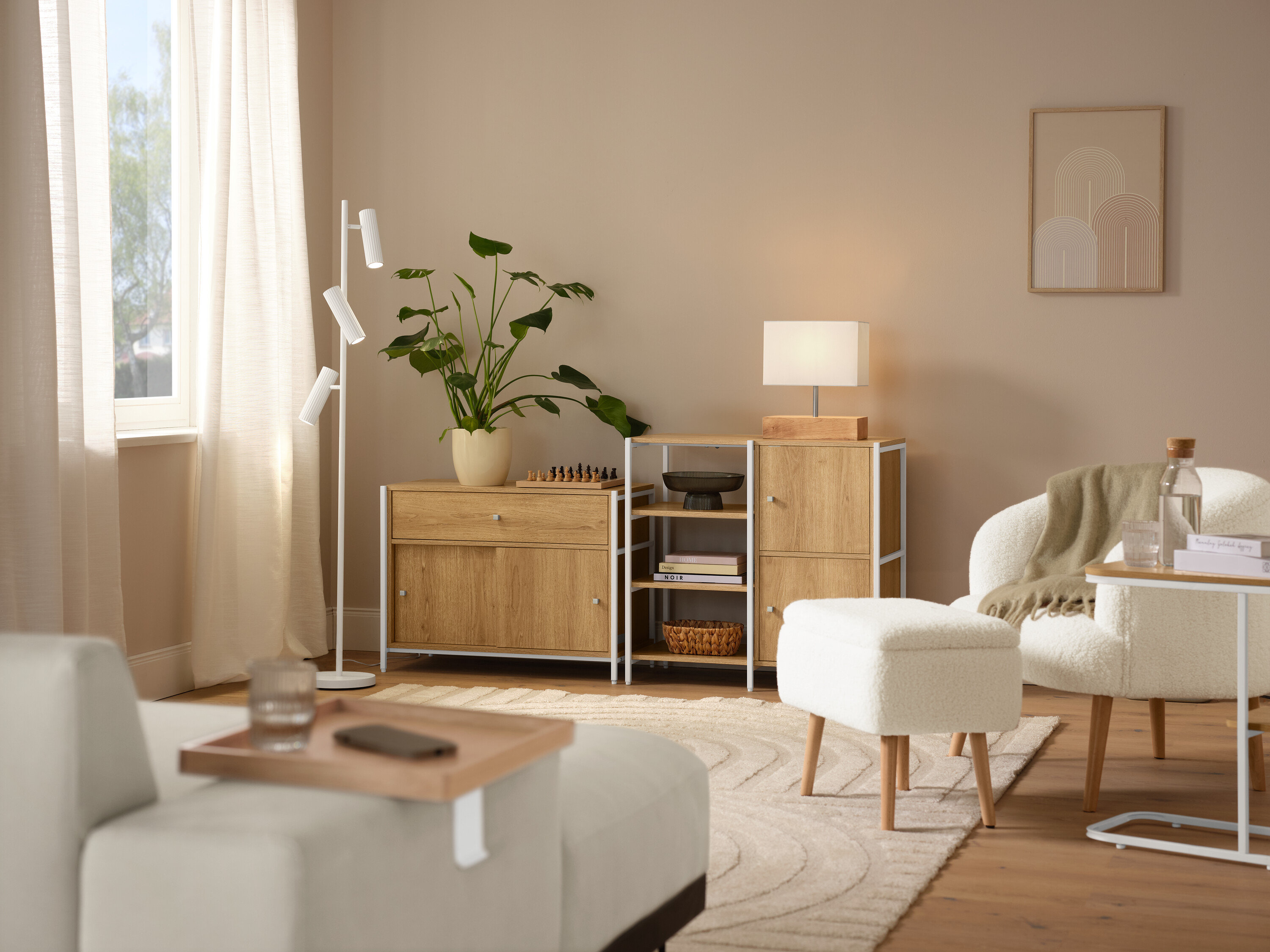 Aranżacja wnętrza z beżowym dywanem »Cosmo«, fotelem z tkaniny bouclé z drewnianymi nogami i lampą stołową z drewnianą podstawą.