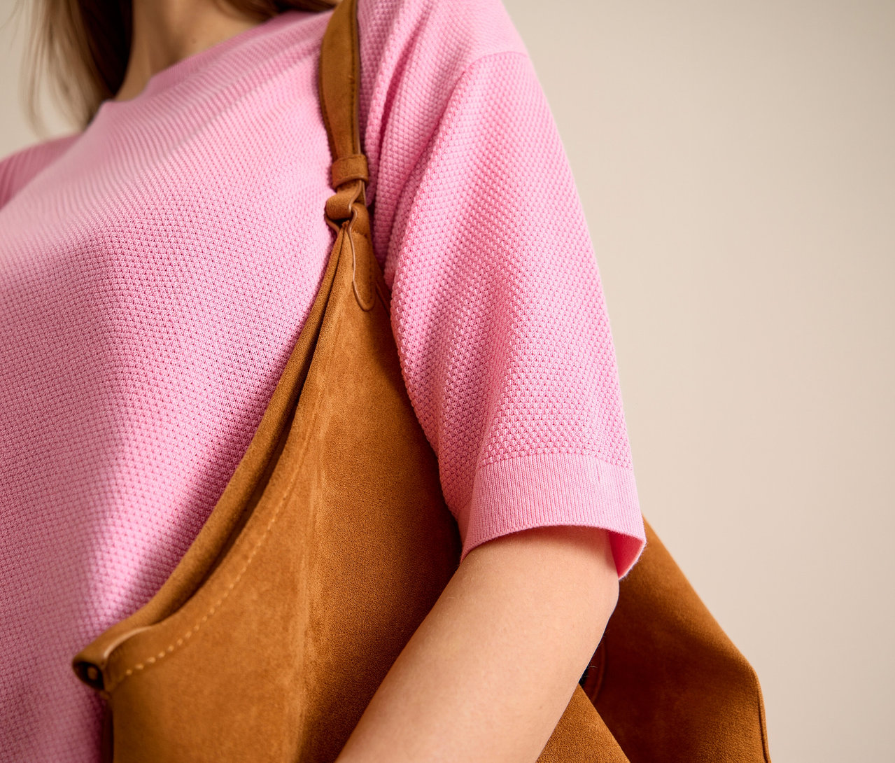 Kobieta ma na sobie różowy sweter z krótkim rękawem CECIL i brązową torbę na ramieniu.