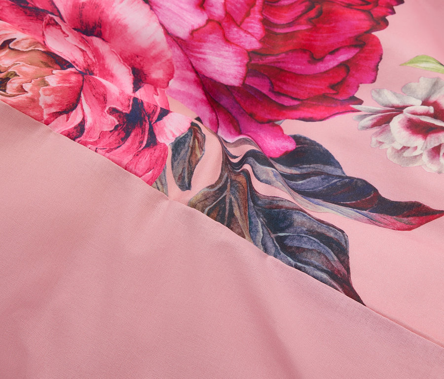 Zbliżenie różowej tkaniny we wzory kwiatowe.