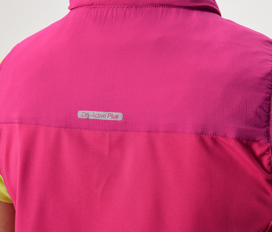 Widok z tyłu osoby ubranej w różową kamizelkę z napisem „Dry Active Plus” na jasnozielonej koszulce.