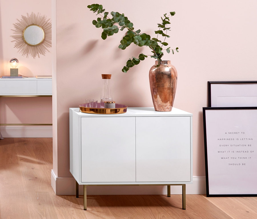 Pokój z fotelem, konsolą z szufladami, szafką typu sideboard i dywanem z długim włosiem.