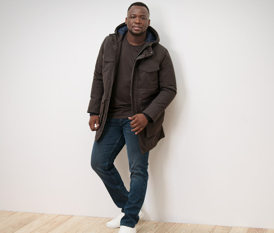 Mężczyzna pozuje w parce i 2 koszulkach z długim rękawem.