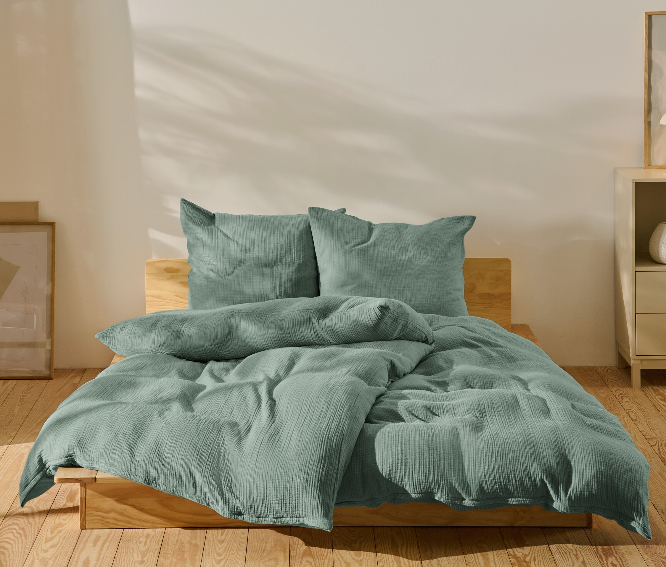 Zielona pościel muślinowa w rozmiarze standardowym i niestandardowym na łóżku.