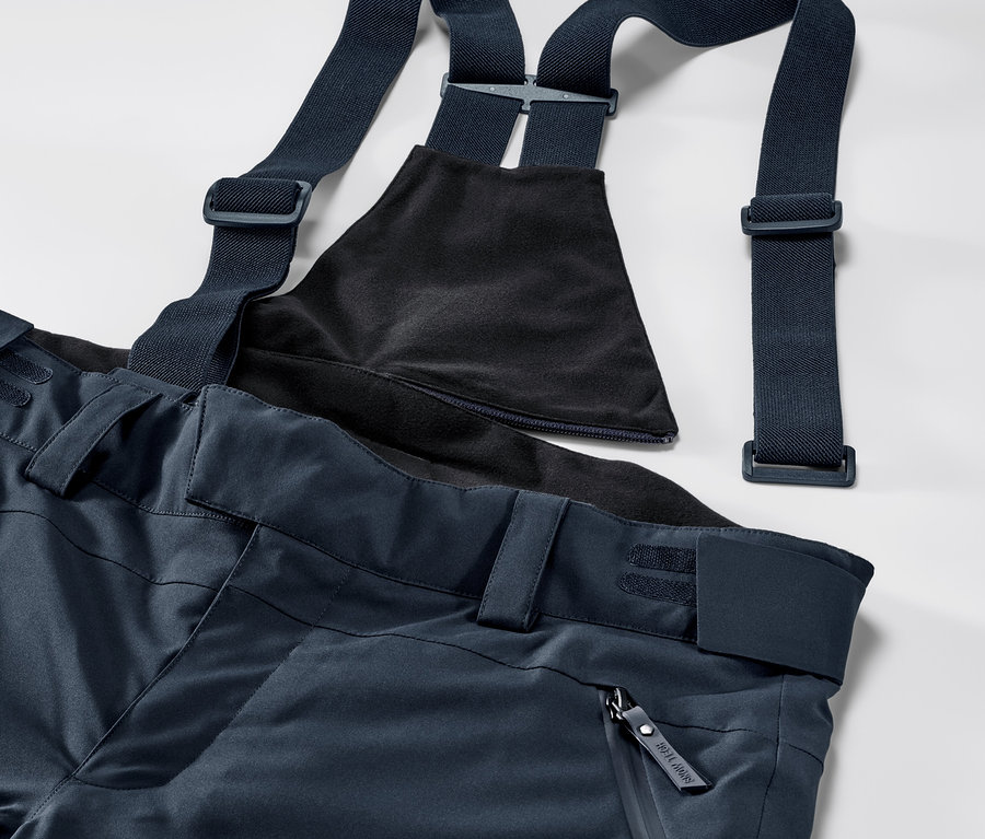 Niebieskie, profesjonalne spodnie narciarskie z regulowanymi szelkami i karczkiem.