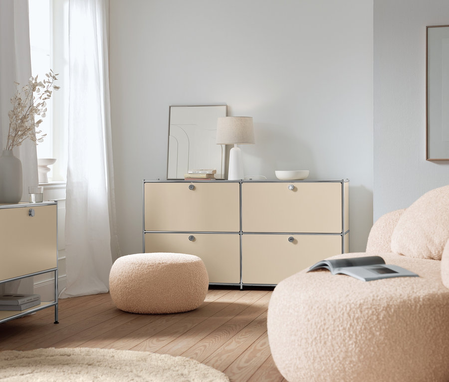 Beżowa metalowa szafka typu sideboard „CN3” z 4 klapami, biała lampa stołowa z kloszem z tkaniny i beżowa metalowa szafka typu sideboard „CN3” z klapą w salonie.