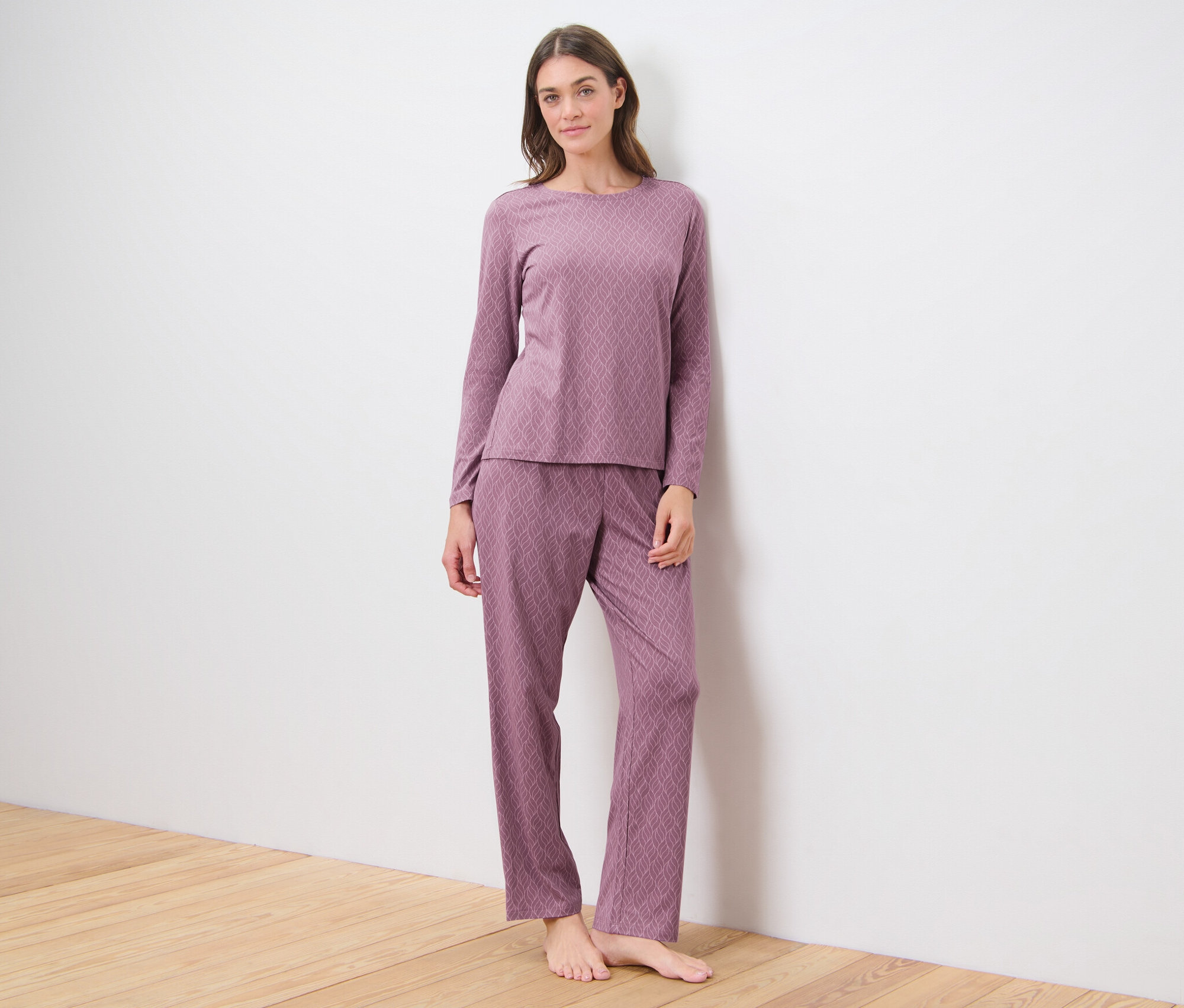 Kobieta stoi w różowej piżamie.