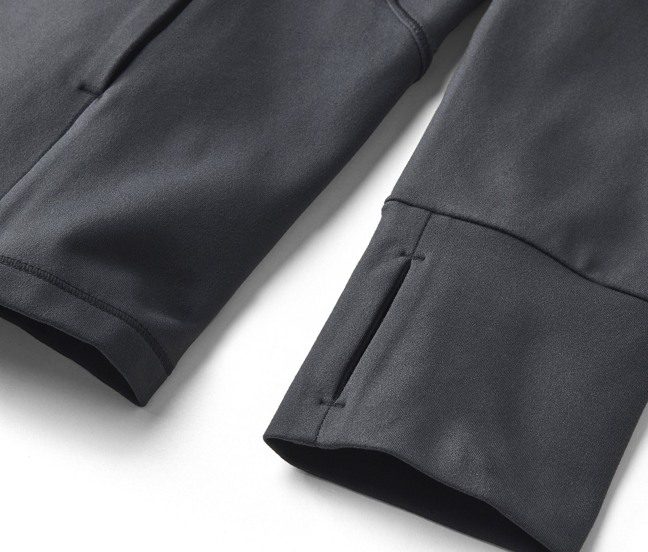 Zbliżenie na szarą bluzę z otworami na kciuki przy mankietach i boczną kieszenią.