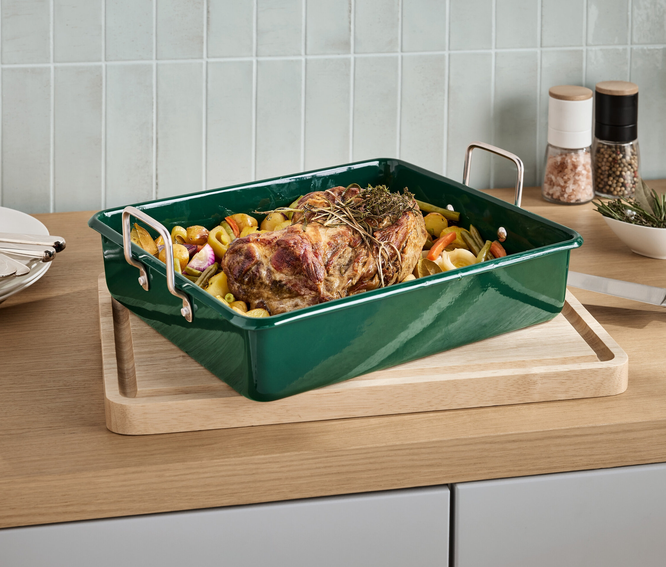 Pieczeń z ziołami w zielonej formie do pieczenia na desce.