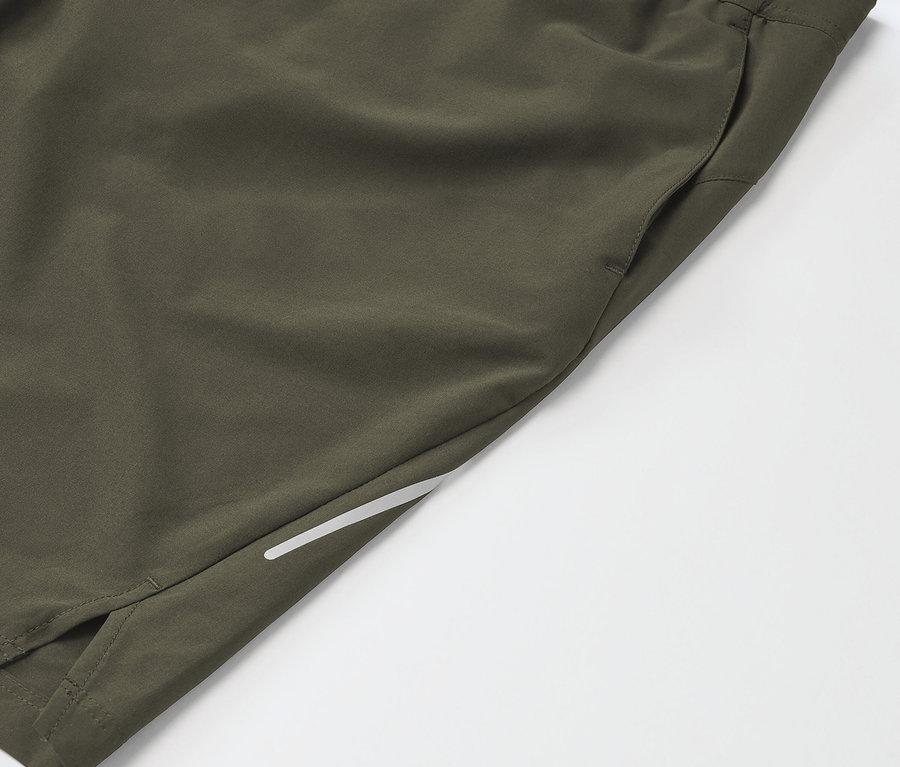 Zbliżenie na khaki sportowe spodenki z kieszenią i odblaskowym paskiem.