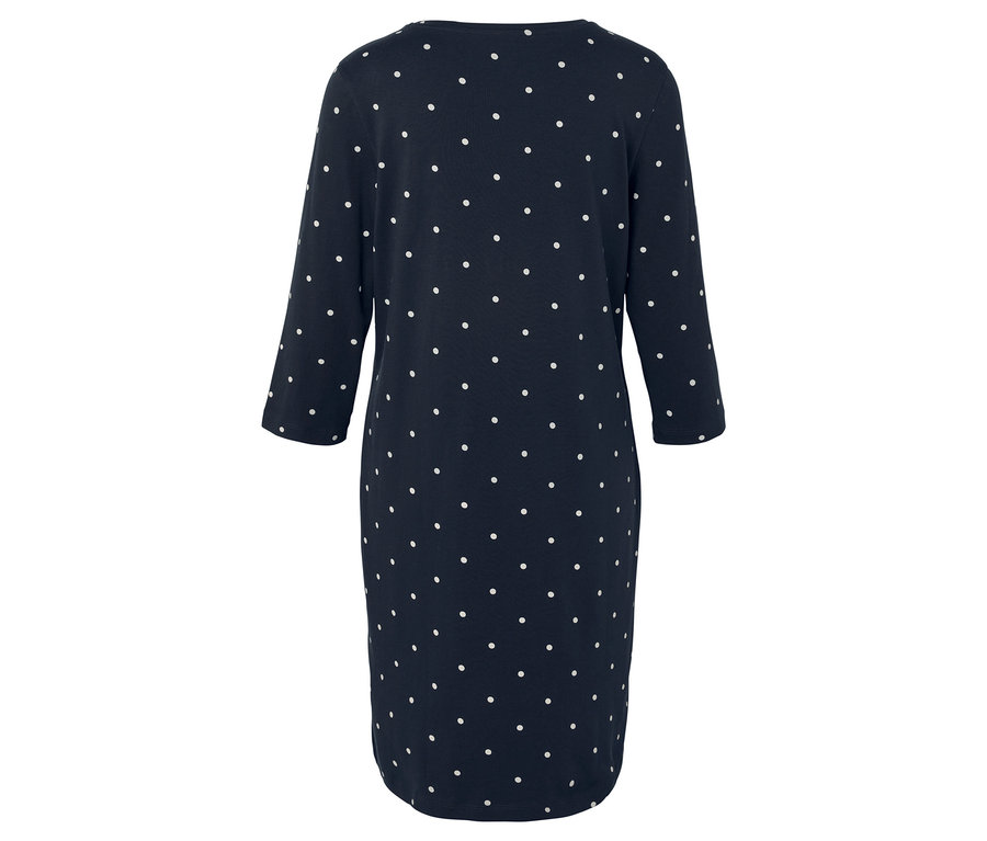 Widok z tyłu granatowej sukienki w białe kropki z rękawami trzy czwarte.