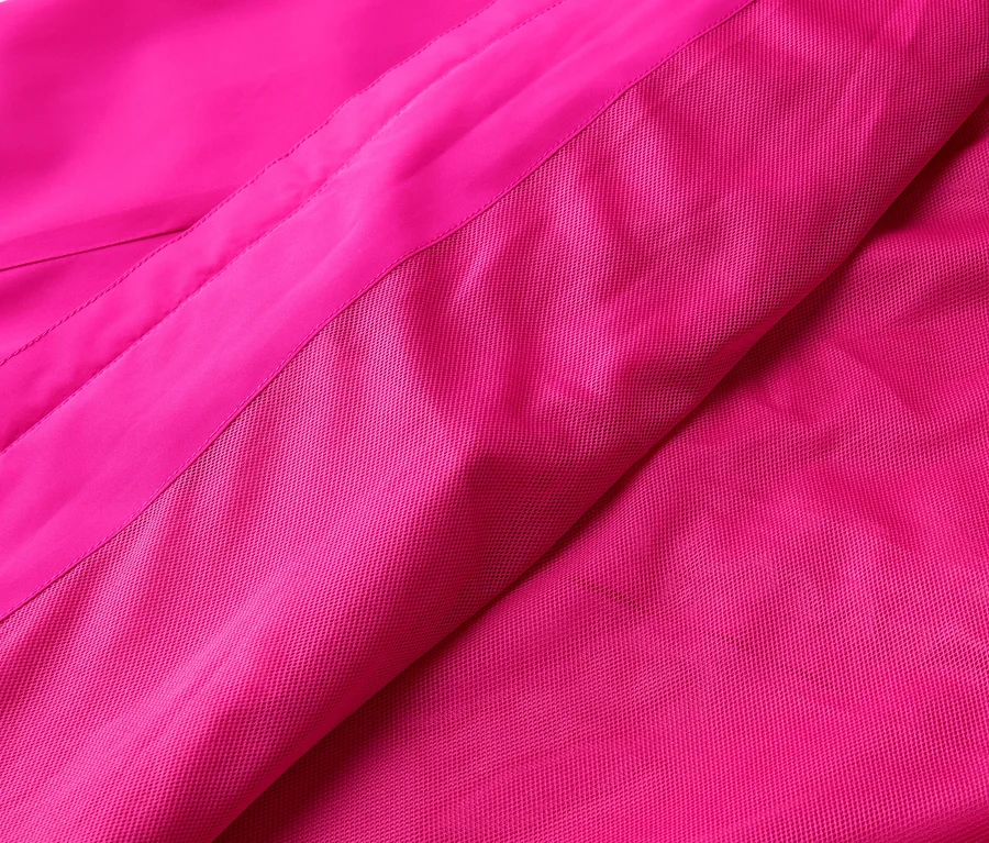 Zbliżenie różowej tkaniny o gładkiej i teksturowanej powierzchni.