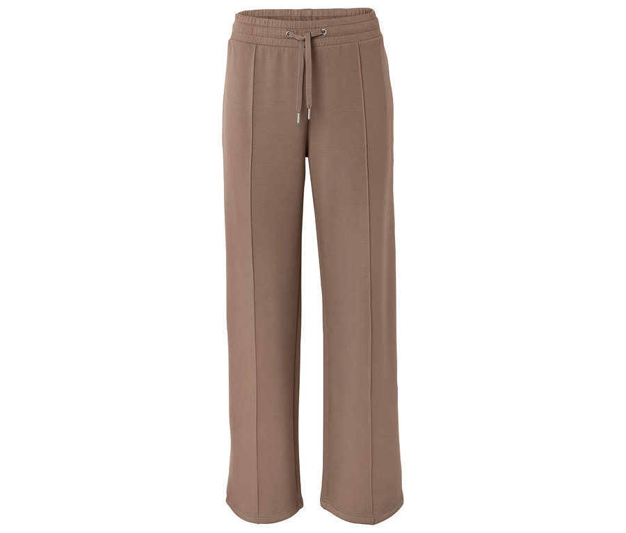 Na białym tle leżą szerokie, brązowe spodnie dresowe ze sznurkiem w pasie.