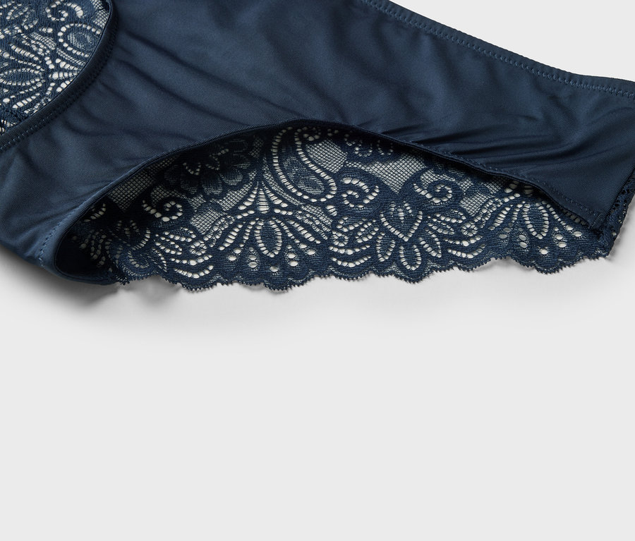 Zbliżenie granatowych damskich majtek z koronkowym wykończeniem.