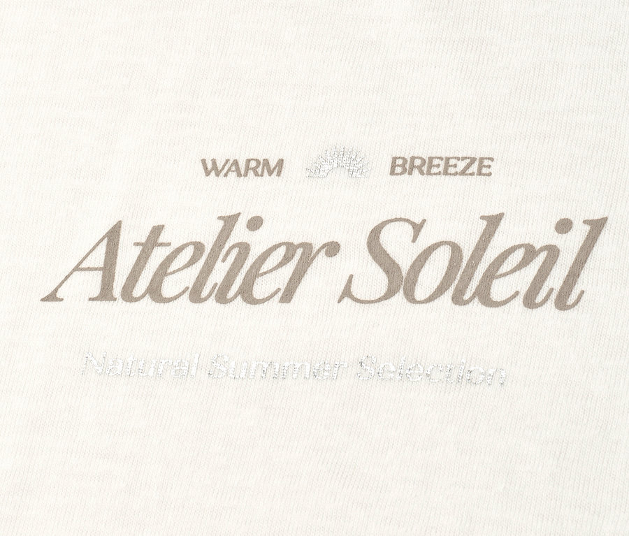 Na kremowym tle szary napis „Atelier Soleil”.