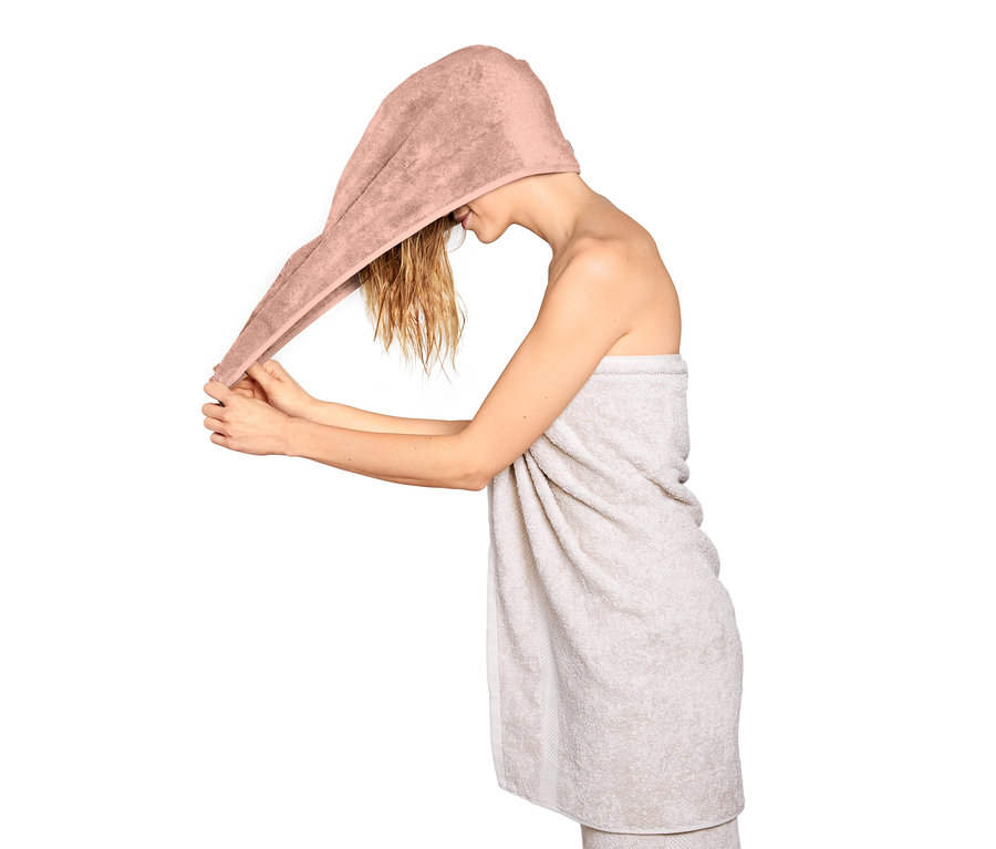 Kobieta zakłada różowy ręcznik turban.