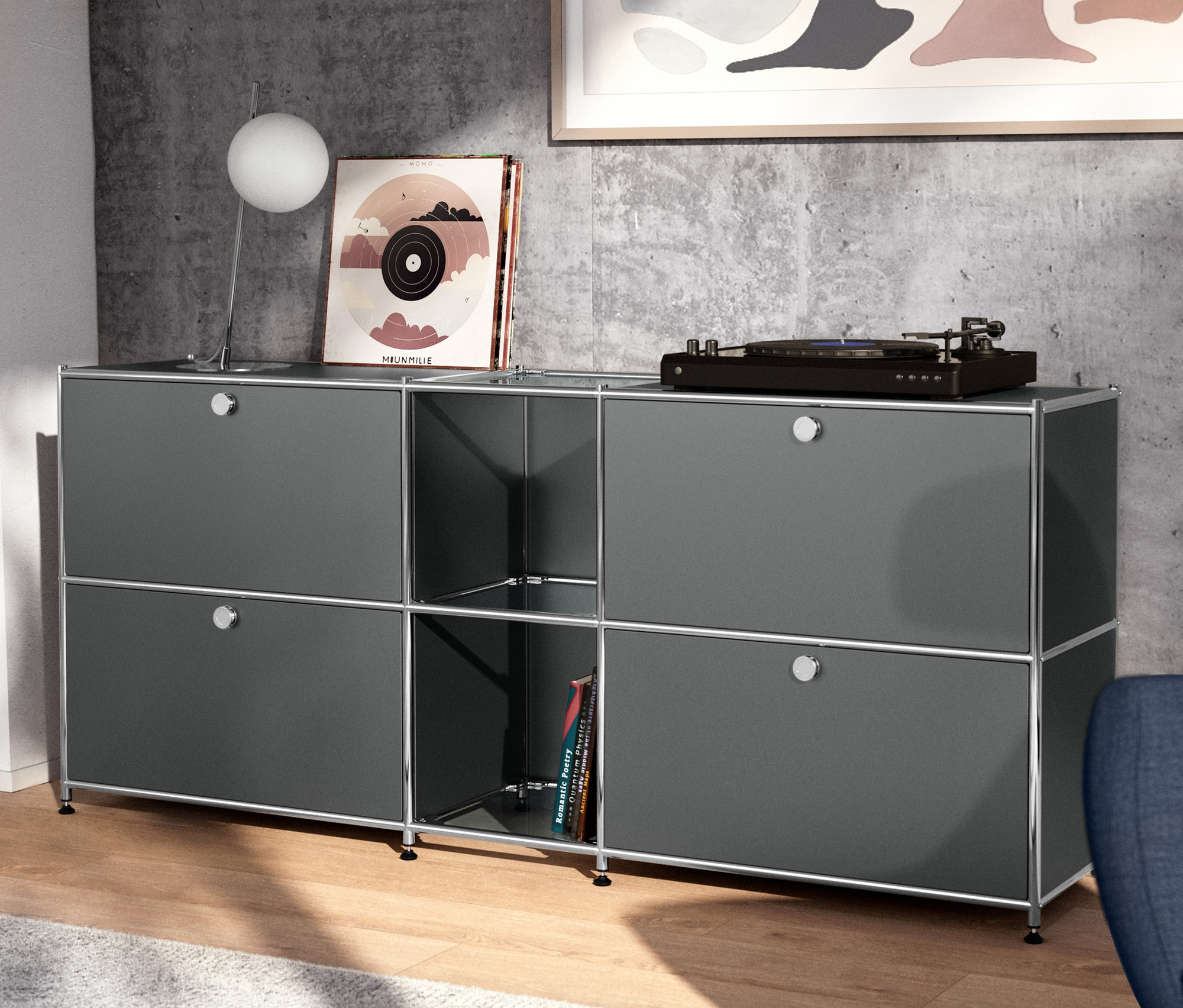 Chromowana metalowa lampa stołowa stoi na szarej metalowej szafce typu sideboard »CN3« z 4 klapami.