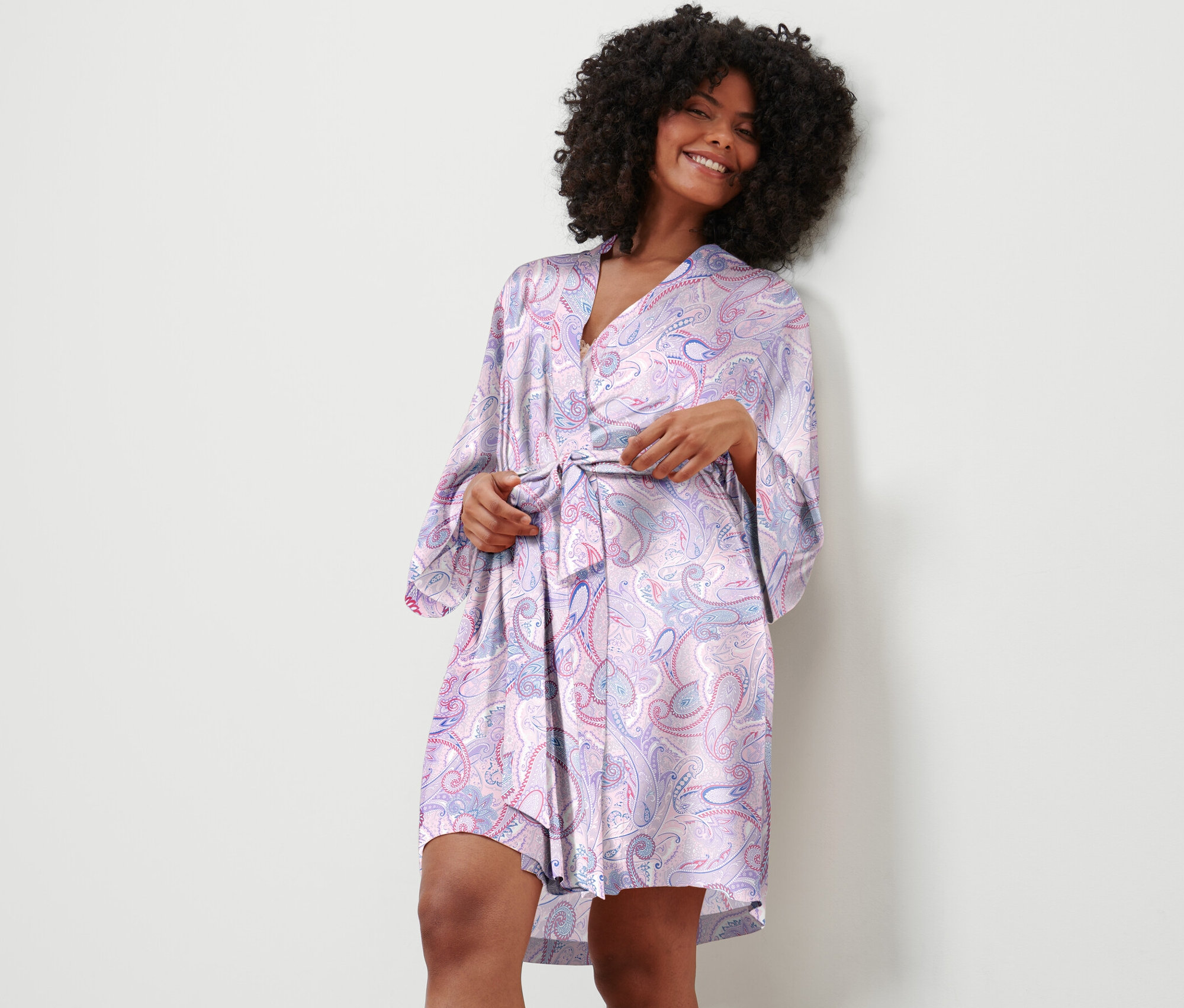 Kobieta zawiązuje szlafrok w wzór paisley.