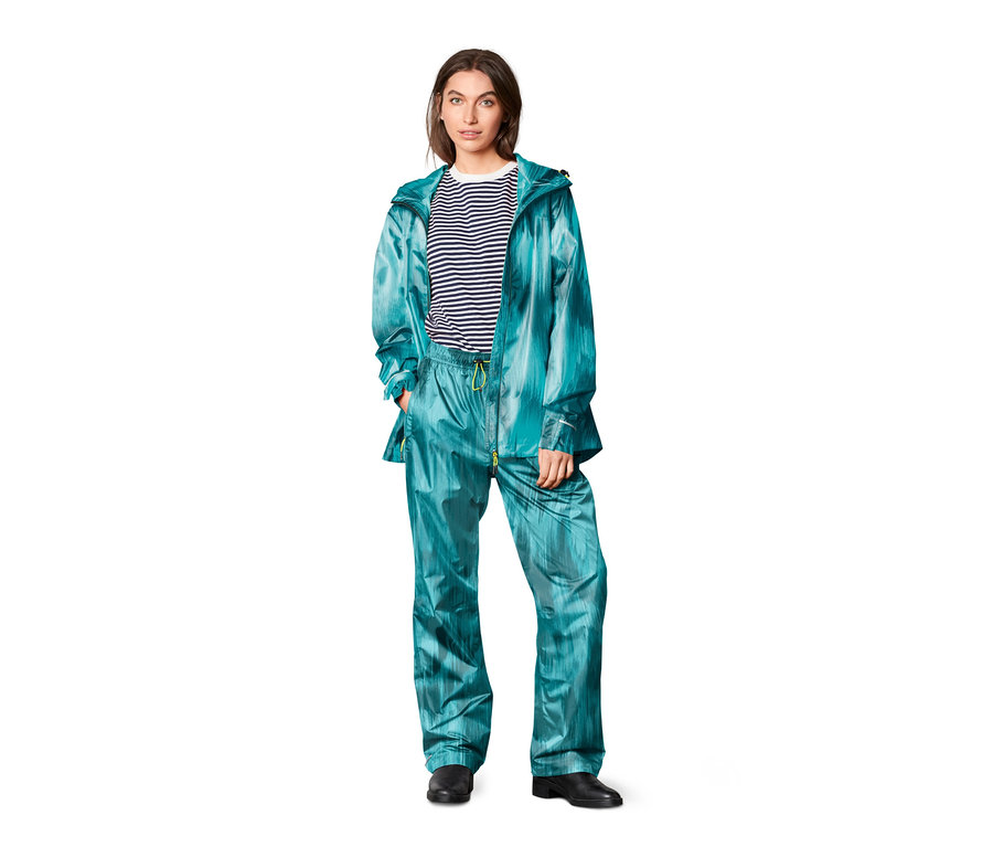 Kobieta ma na sobie kurtkę i Spodnie przeciwdeszczowe, z nadrukiem.