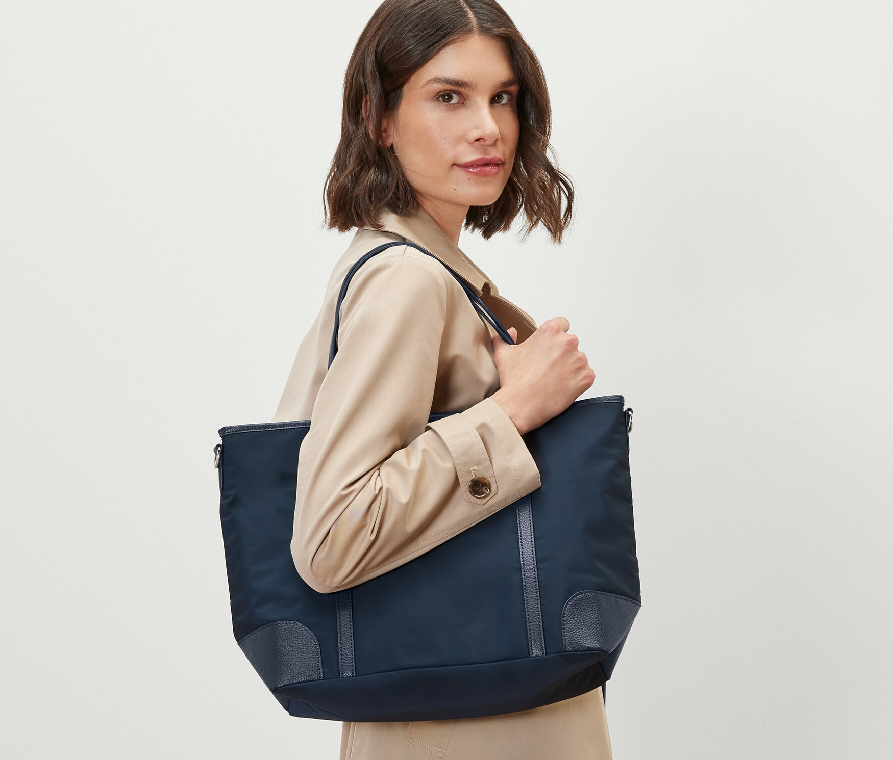 Kobieta trzyma torbę shopperkę.