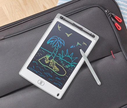 Tablet LCD do pisania z rysunkiem plaży leży na szarej walizce.