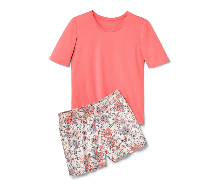 Piżama z krótkimi spodenkami w kolorze papai składająca się z T-shirtu i kwiecistych szortów leży na sobie.