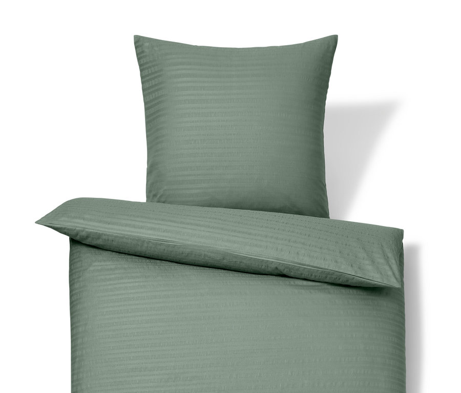 Zielona pościel z kory w rozmiarze standardowym i niestandardowym leży na białym tle.