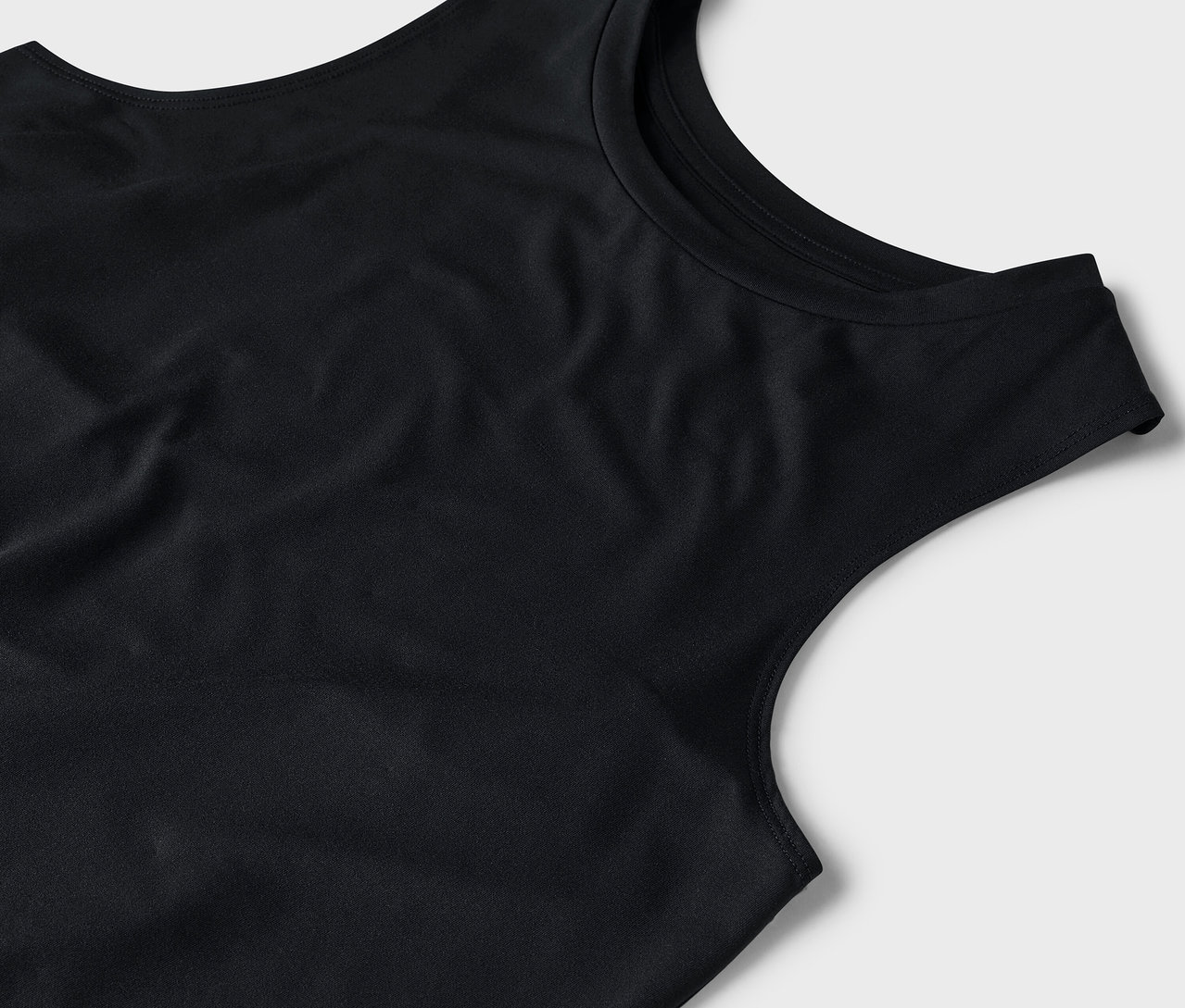 Zbliżenie na czarny podkoszulek na szarym tle.