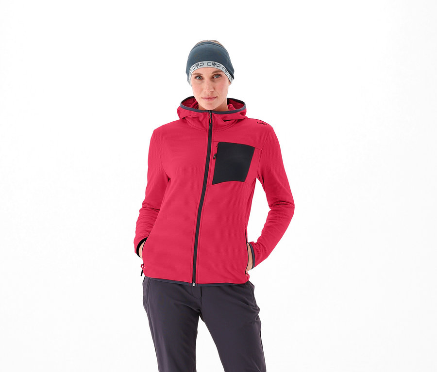 Kobieta ma na sobie czerwoną kurtkę CMP i szarą czapkę.