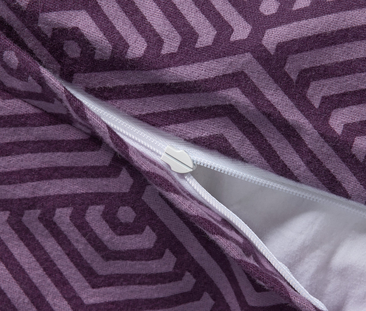 Detal liliowej pościeli z flaneli o standardowym rozmiarze z zamkiem błyskawicznym.