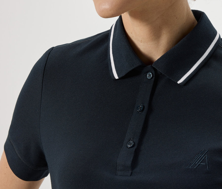 Zbliżenie na granatową damską koszulkę polo z białym obszyciem kołnierzyka.
