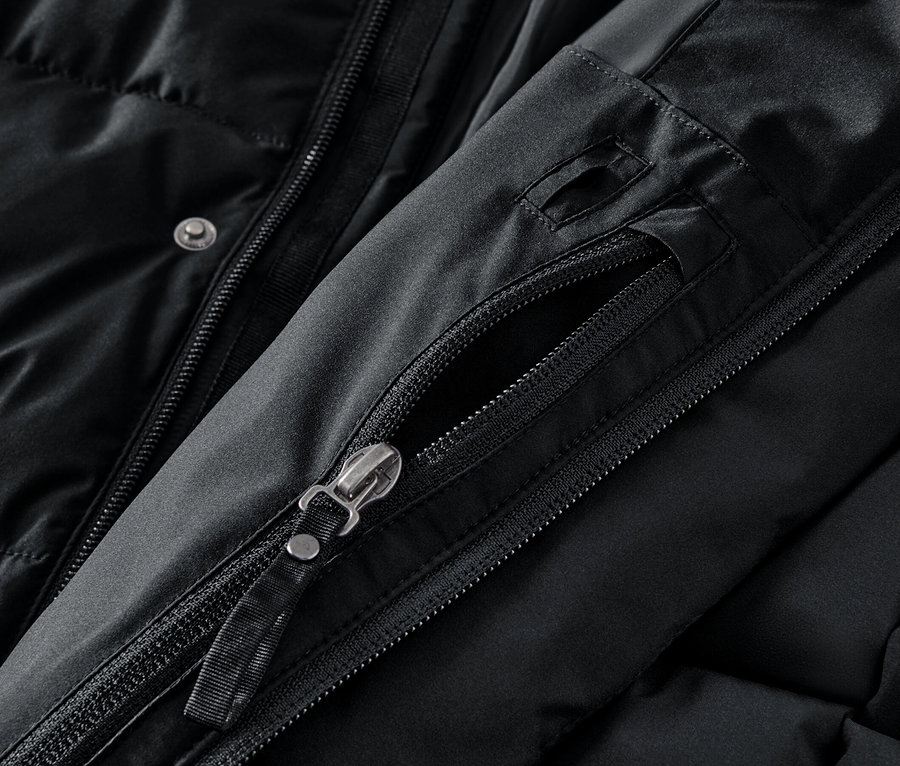 Szczegół czarnej kurtki z rozpiętym zamkiem błyskawicznym kieszeni.