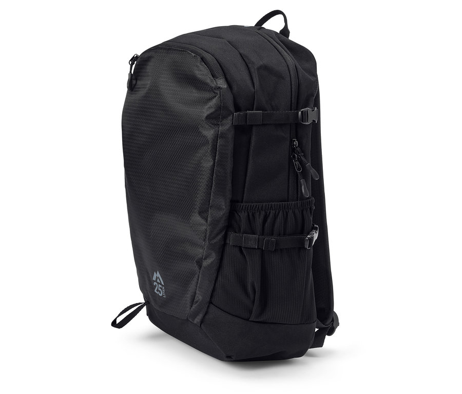 Czarny plecak stoi na białej powierzchni.