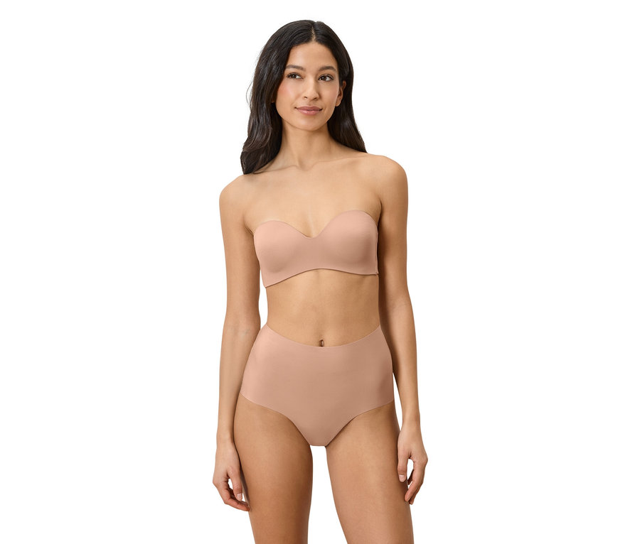 Kobieta ma na sobie beżowy biustonosz bez ramiączek i majtki z wysokim stanem.