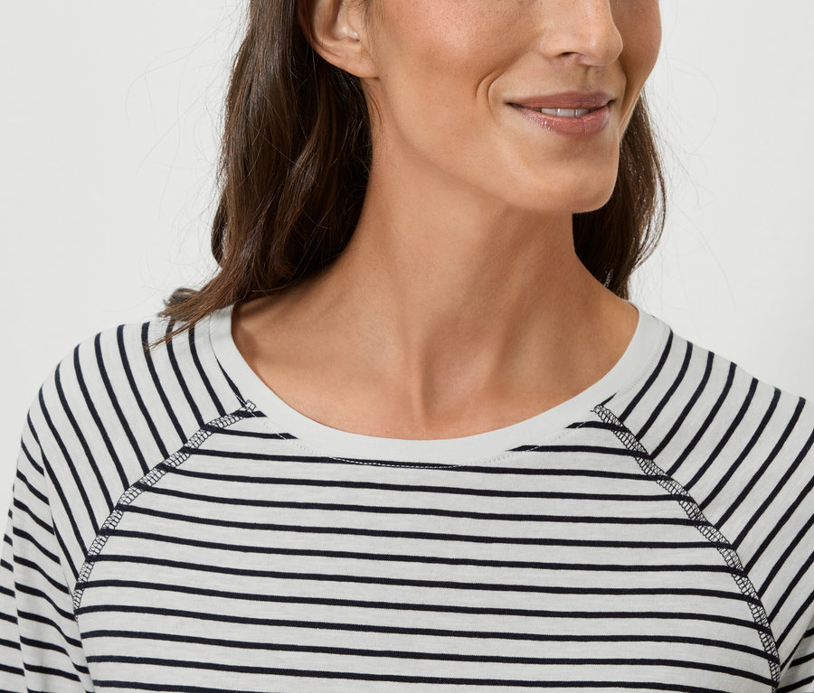 Portret kobiety w bluzce w paski z długim rękawem.