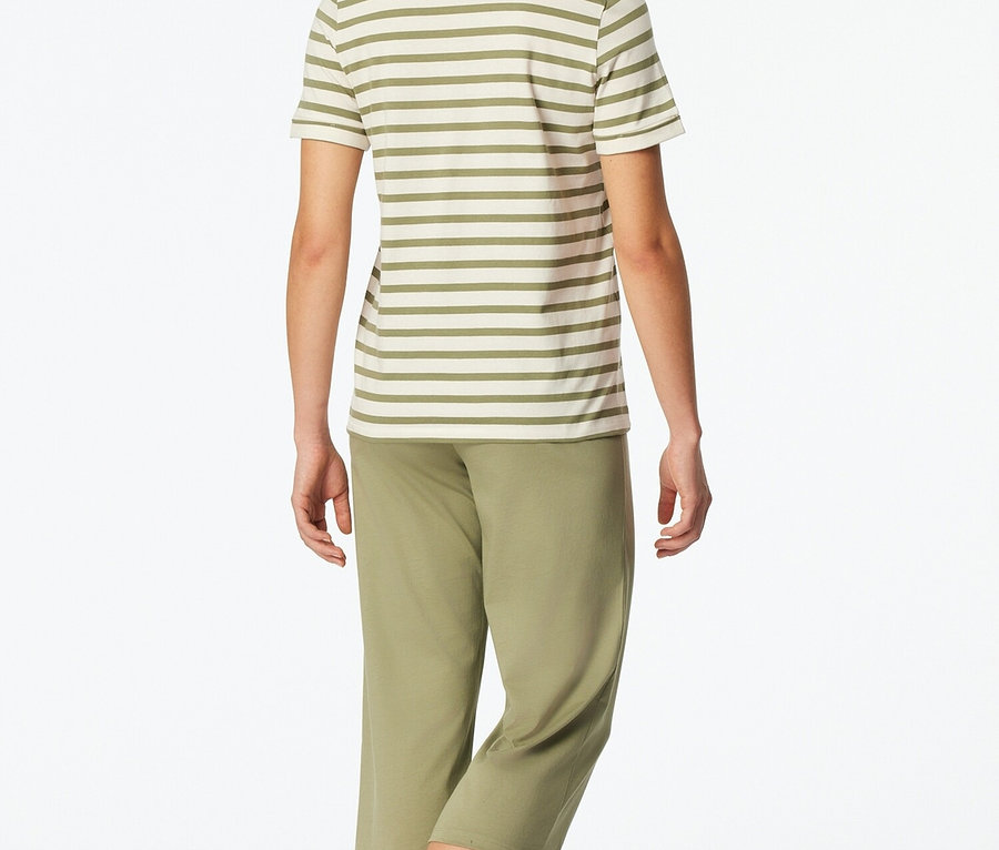 Kobieta od tyłu w bluzce w paski i zielonych spodniach.