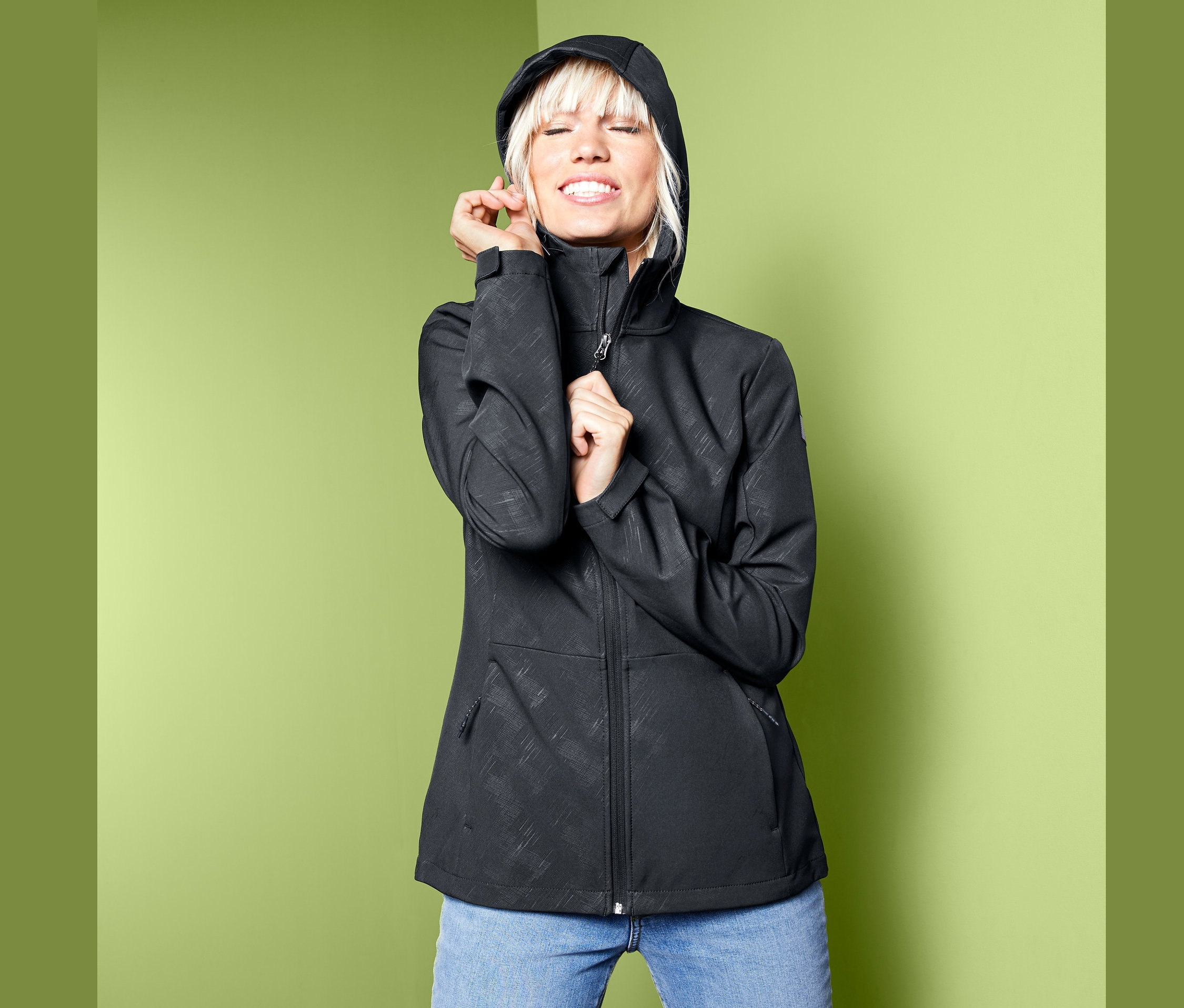 Kobieta pozuje w kurtce softshell.