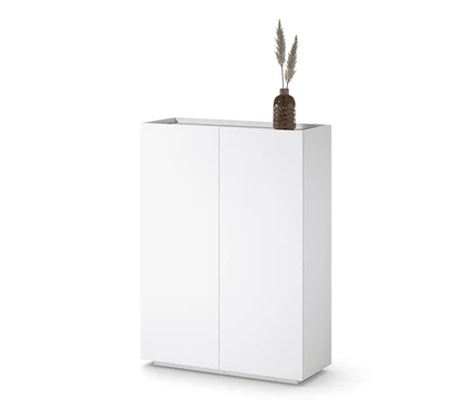 Biała szafa typu highboard z wazonem z trawą na górze.
