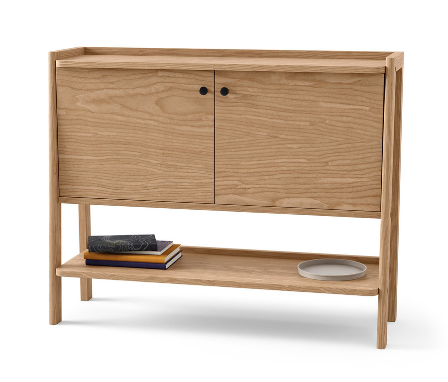 Drewniana szafka z dwojgiem drzwi i półką. Na półce leżą książki i talerz.