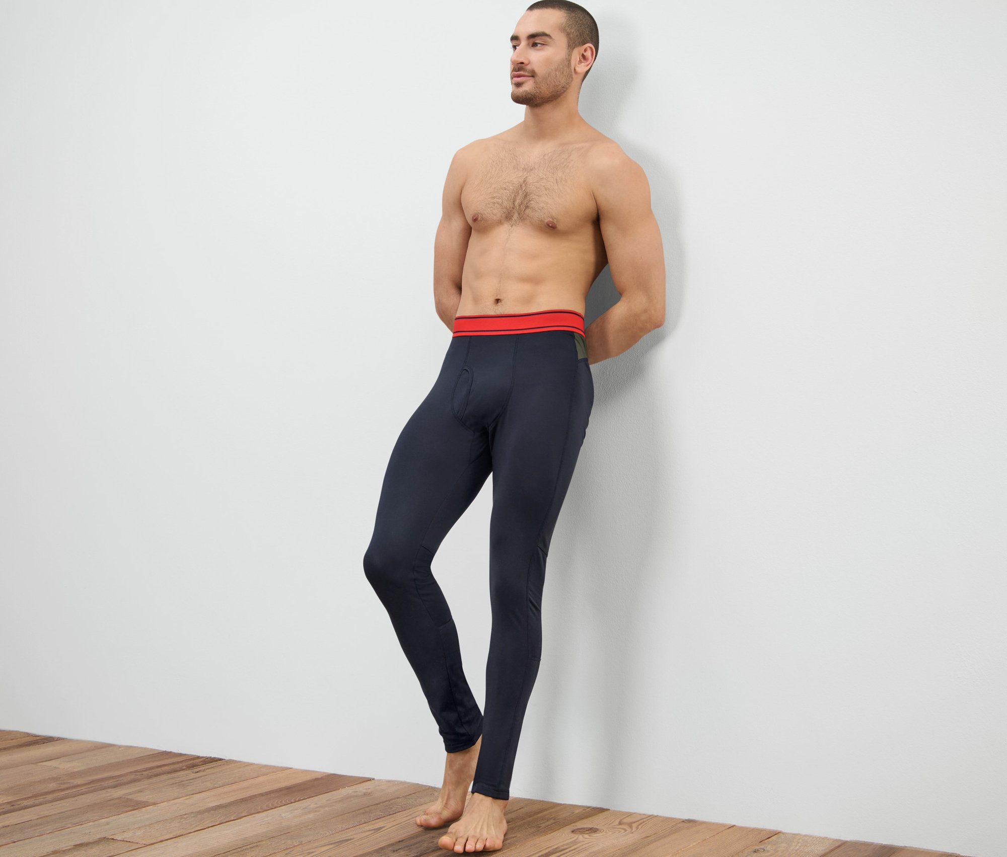 Mężczyzna oparty o ścianę ma na sobie termoaktywne kalesony funkcyjne.