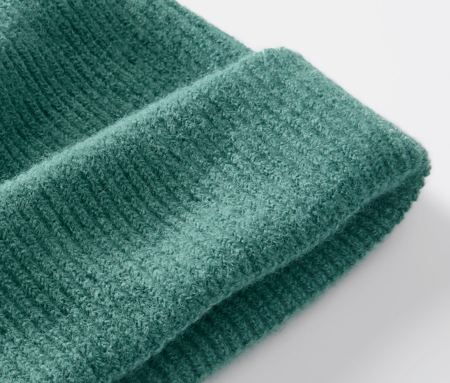 Zbliżenie na zieloną czapkę z dzianiny.